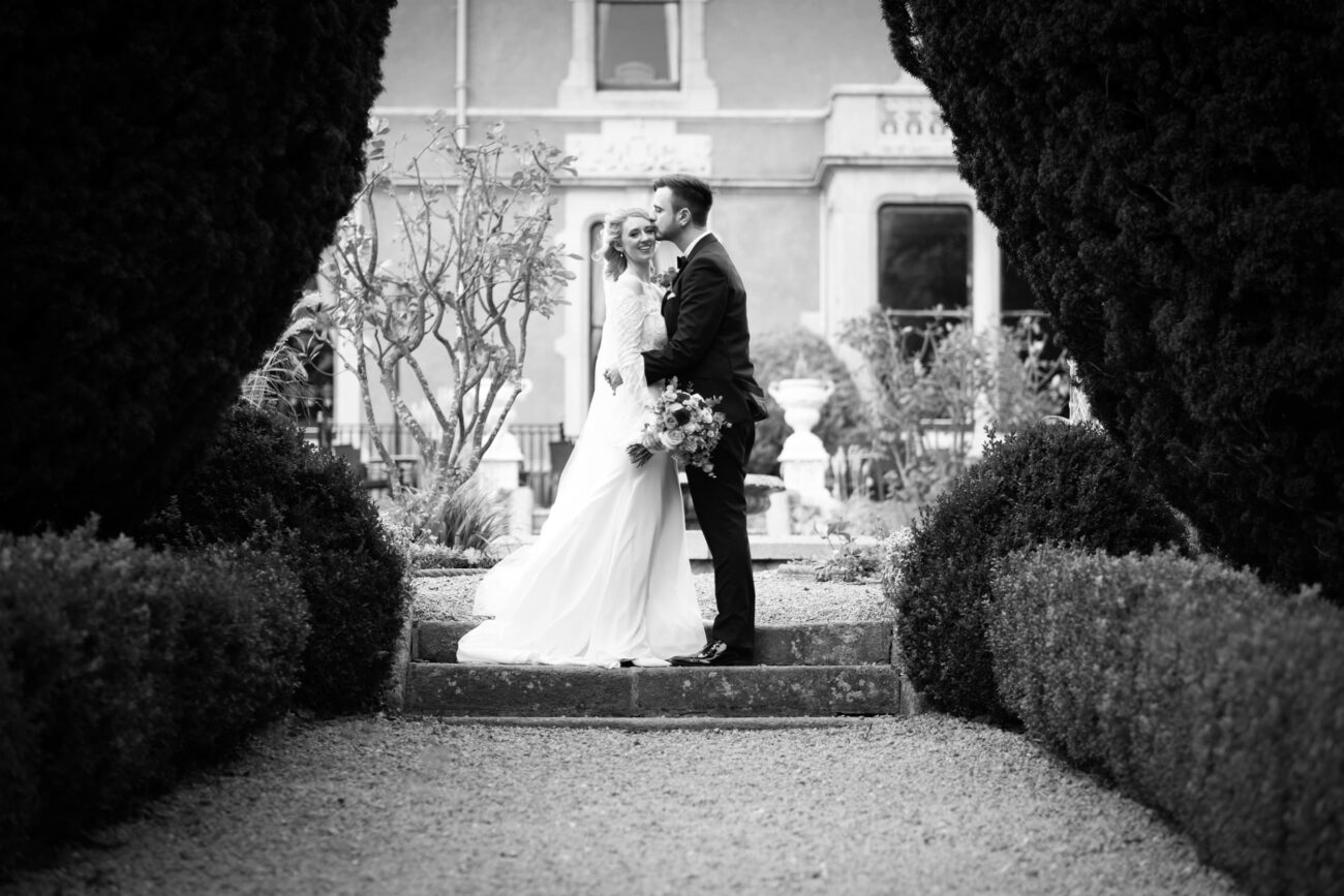 Killashee Hotel wedding, wedding at Killashee Hotel, Couple posing in between large trees at Killashee Hotel gardens