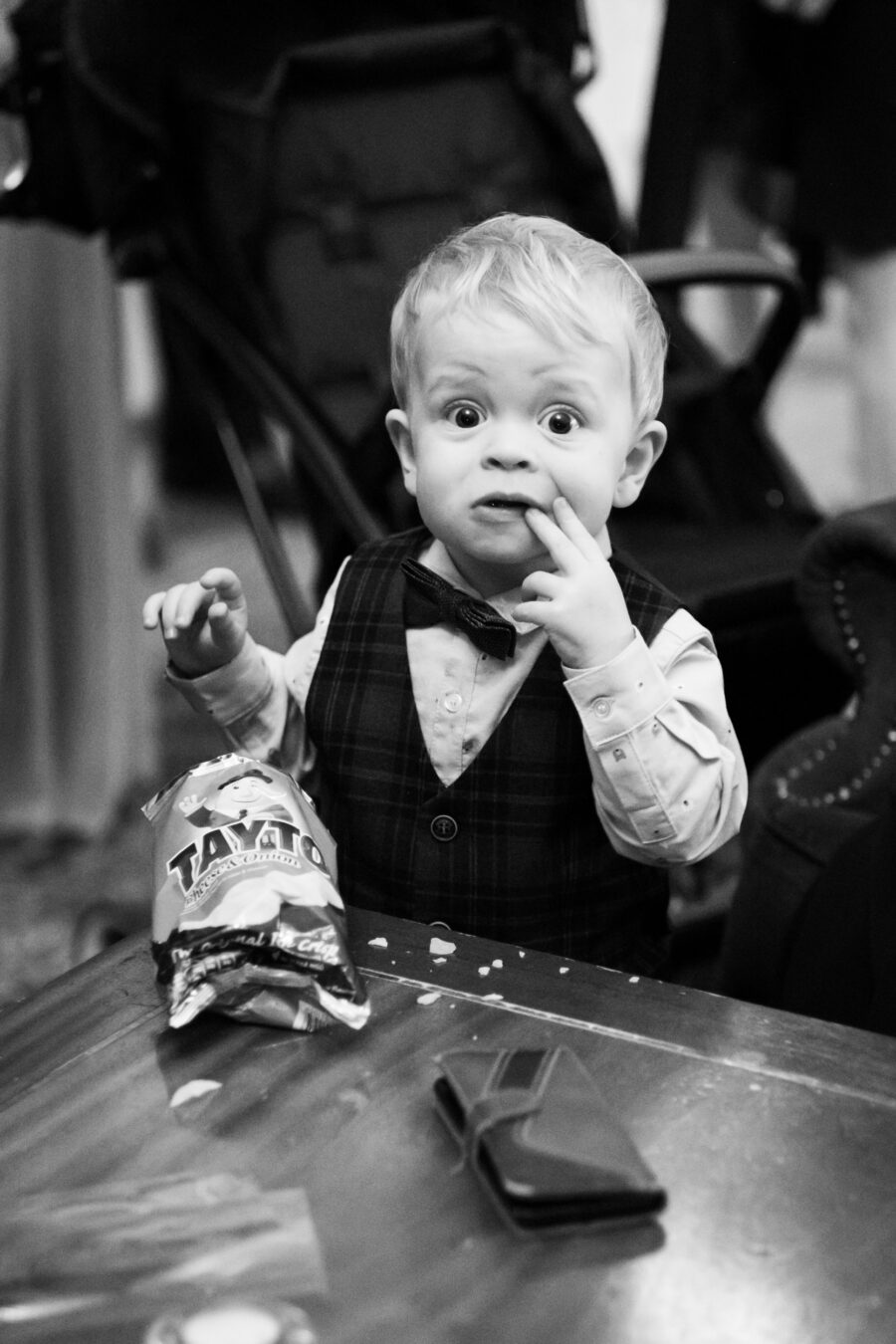 little boy eating at packet of crisps