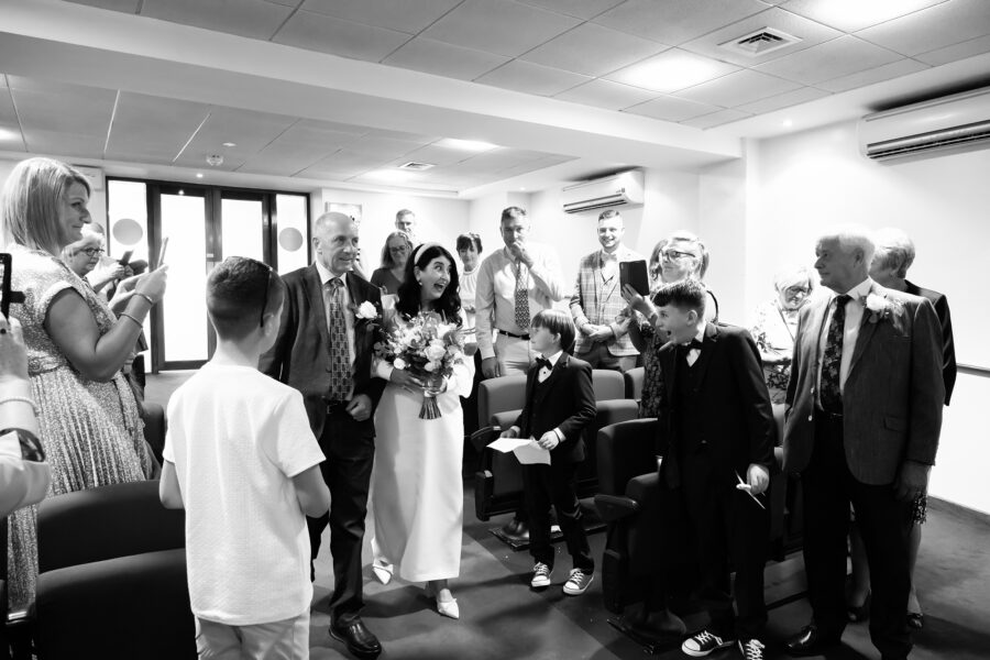 Bride looking at her son whilst walking down the aisle in excitement