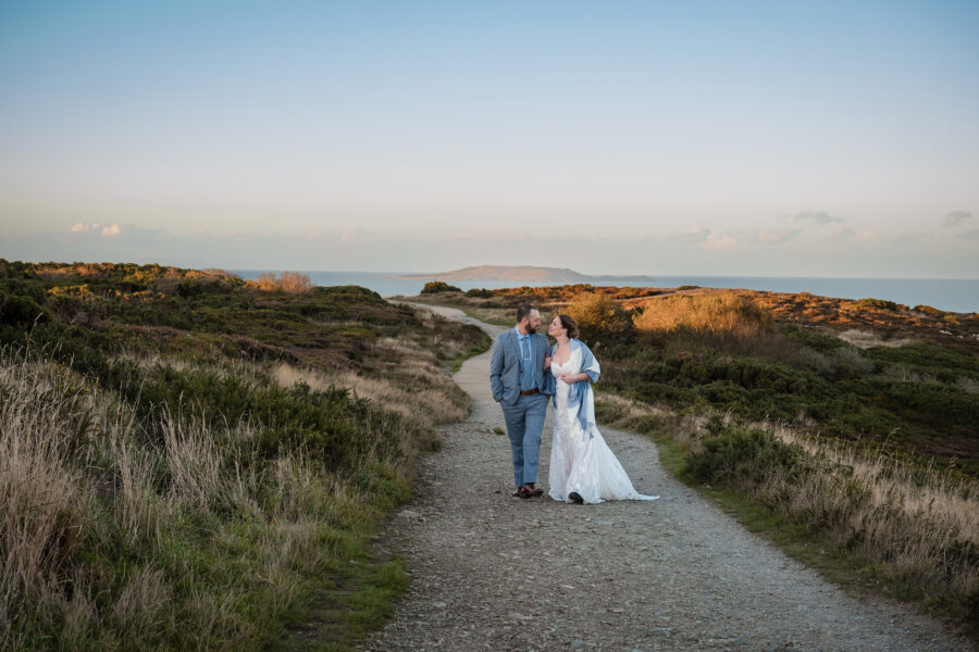 couple walking arm in arm, looking at each other in Howth summit