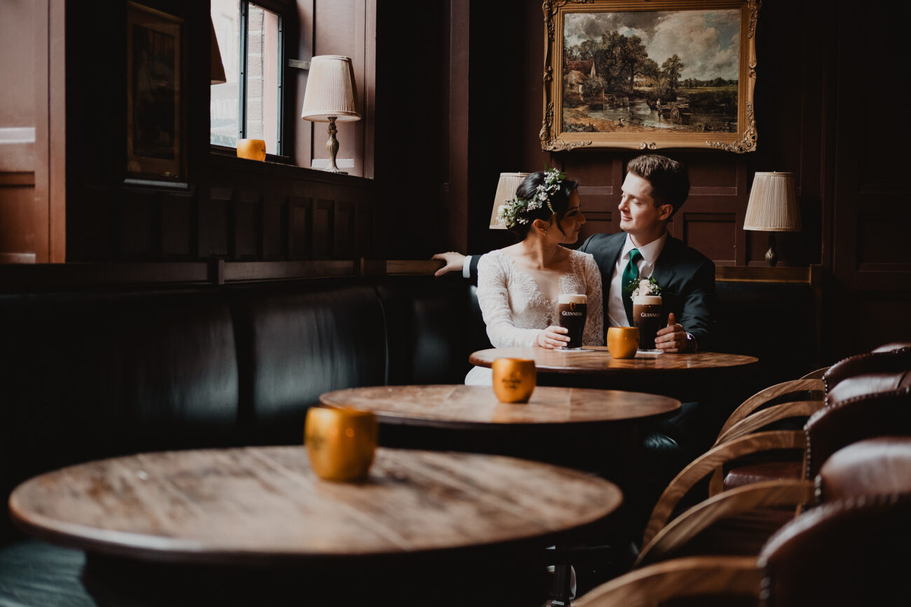 couple drinking a pint of Guinness in and Old Irish pub. Destination wedding in Ireland, Dublin elopement photographer