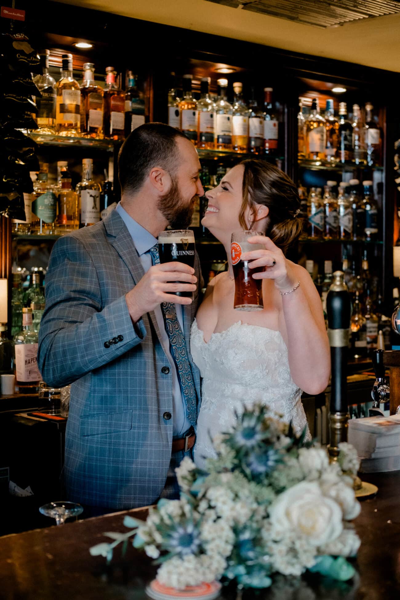 Couple laughing and drinking a beer behind the bar in the Abbey Tavern in Howth