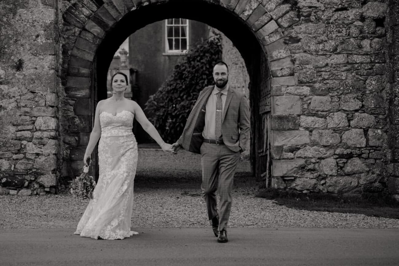 Couple waling and the stone wall of Howth Castle in the background