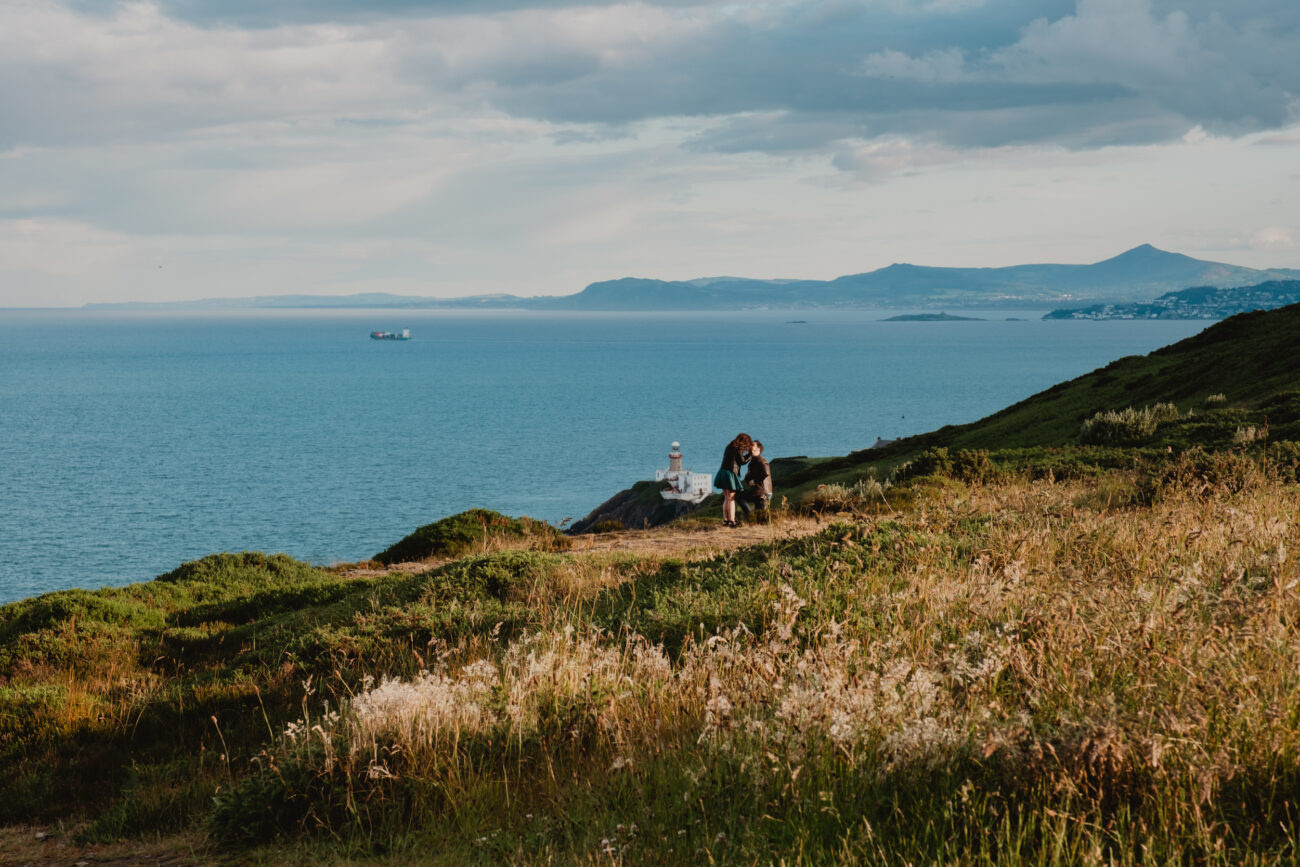 man proposing to his girlfriend on Howth Head, secret proposal on cliffs or Howth