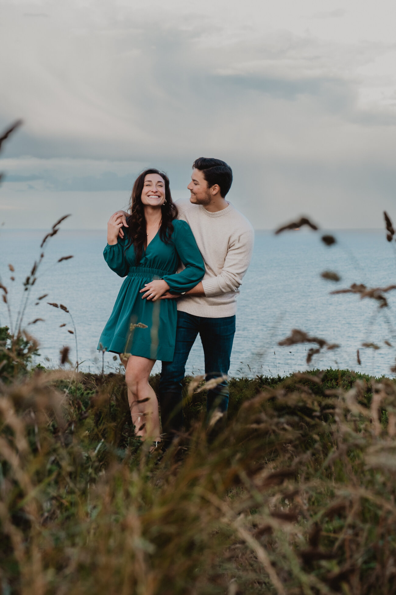 couple laughing on Howth Head. Secret proposal on the cliffs of Howth, Howth engagement shoot