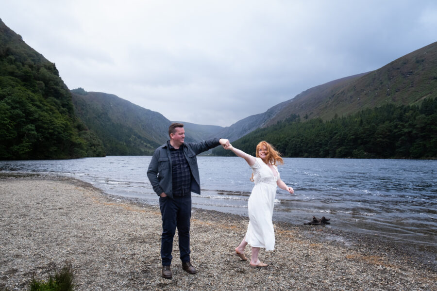 Engagement photography in Glendalough, couple dancing at the upper lake of Glendalough