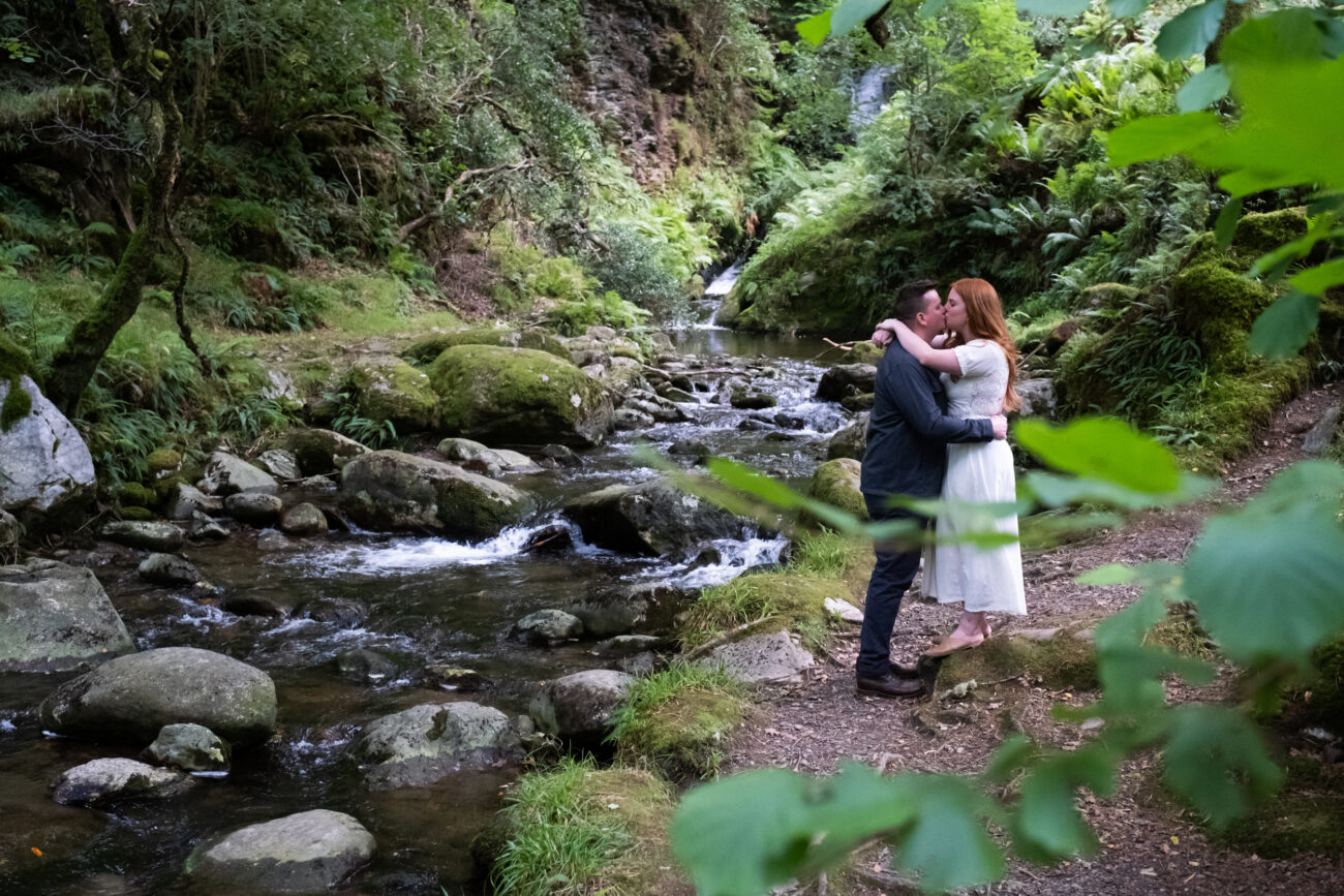 Engagement photography in Glendalough, couple kissing in the waterfalls at Glendalough