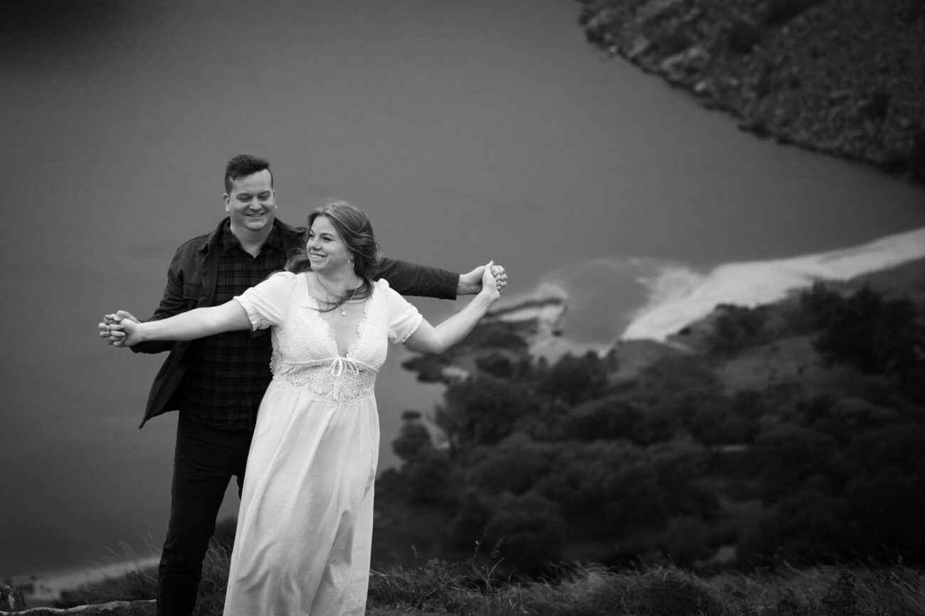 Couple holdind hands and hugging in an engagement shoot in Lough Tay