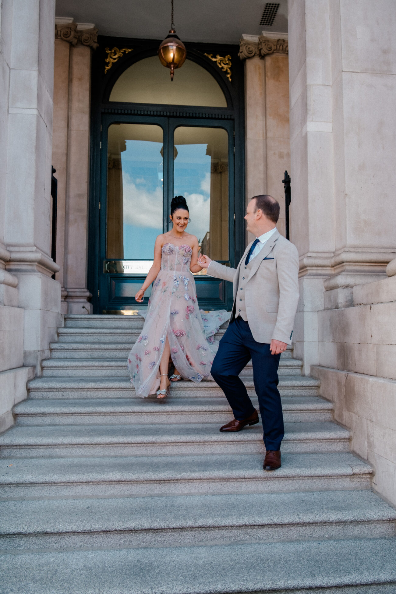 couple walking out of City Hall Dublin, candid wedding portraits