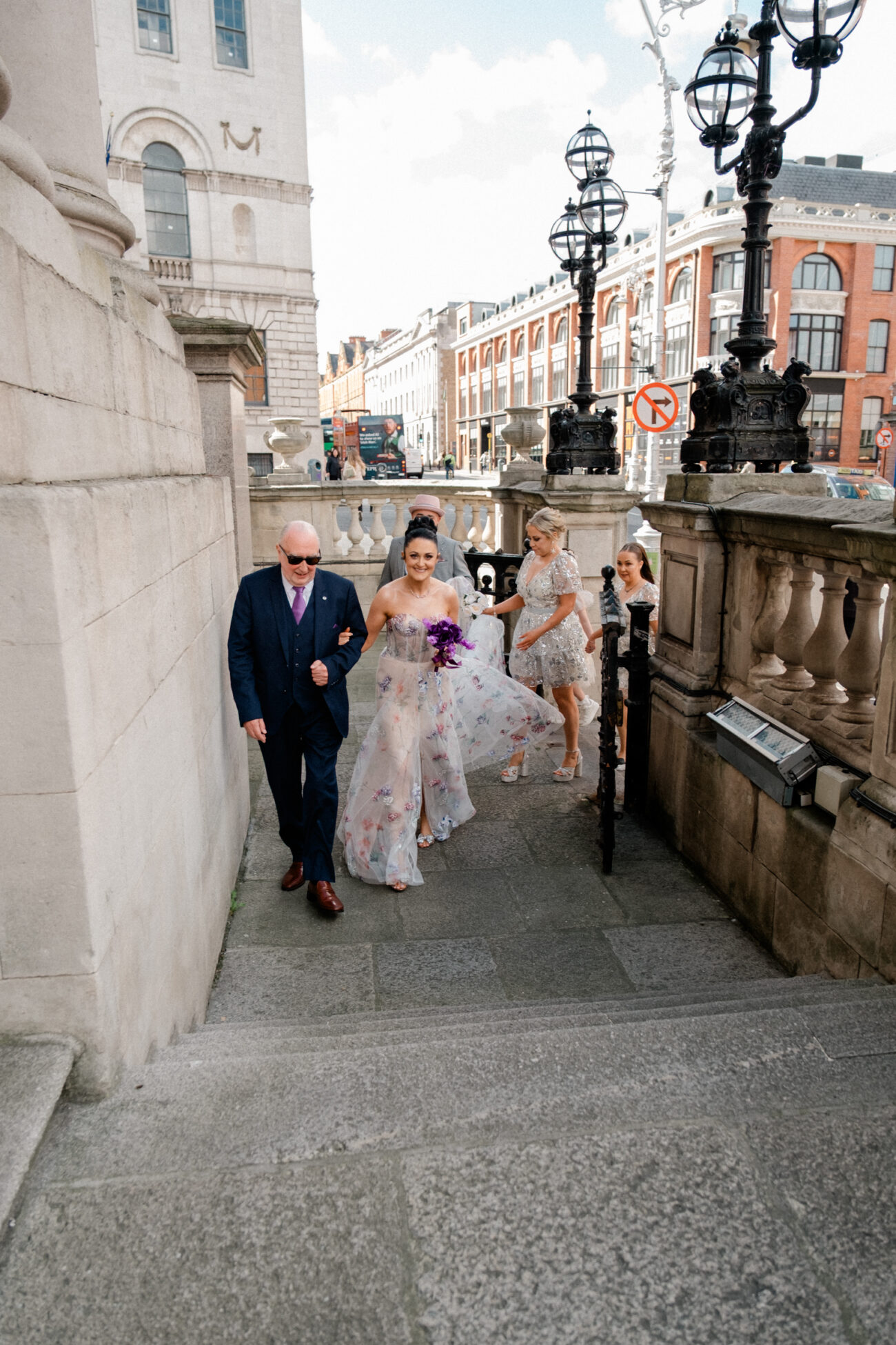 bride walking up the steps of City Hall with her father