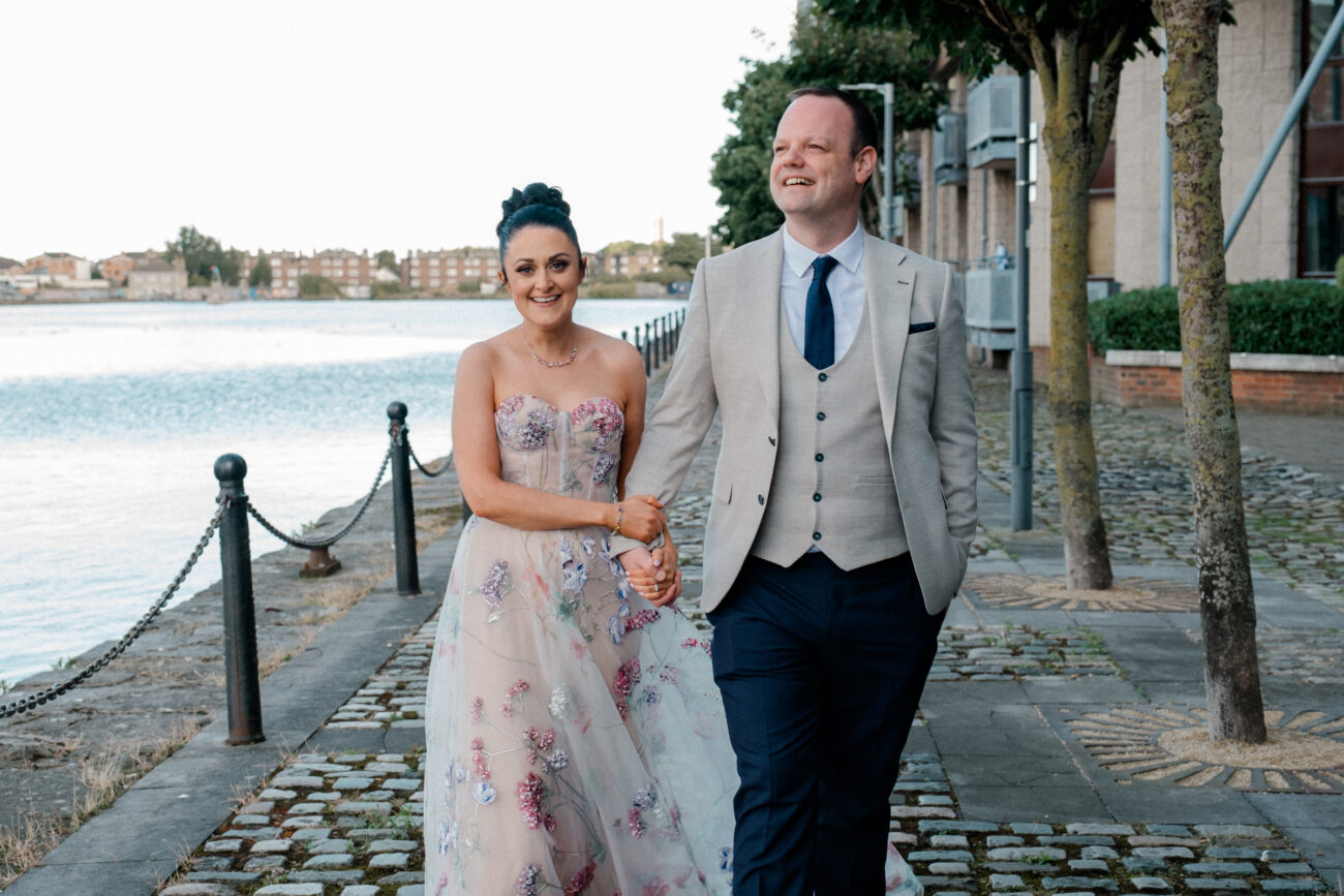 Couple walking and smiling at each other outside Charlotte Quay