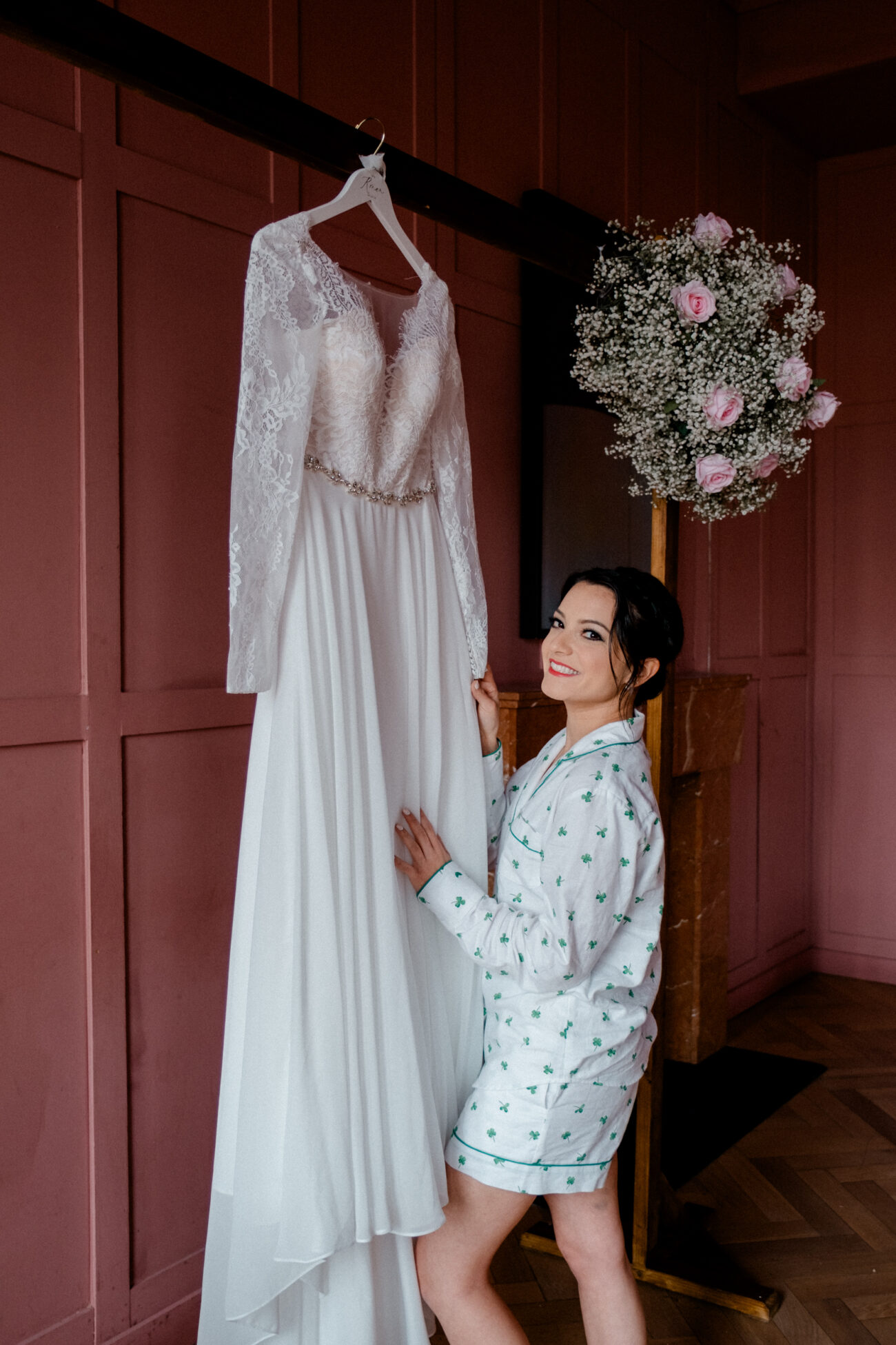 bride smiling and looking at the camera whilst holding her dress at The Clarence Hotel. Candid wedding portrait. Dublin elopement
