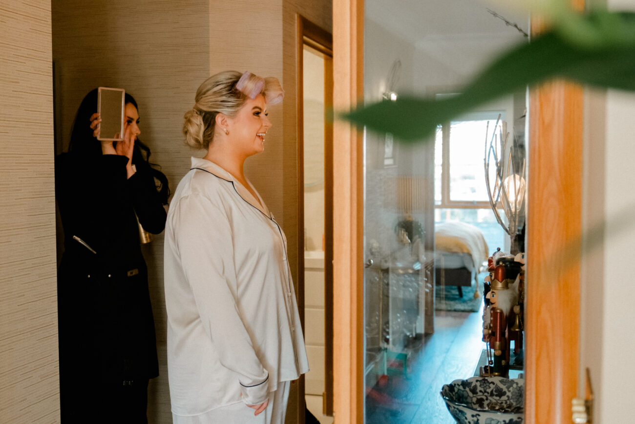 Bride looking at her hair in the mirror, candid wedding photography