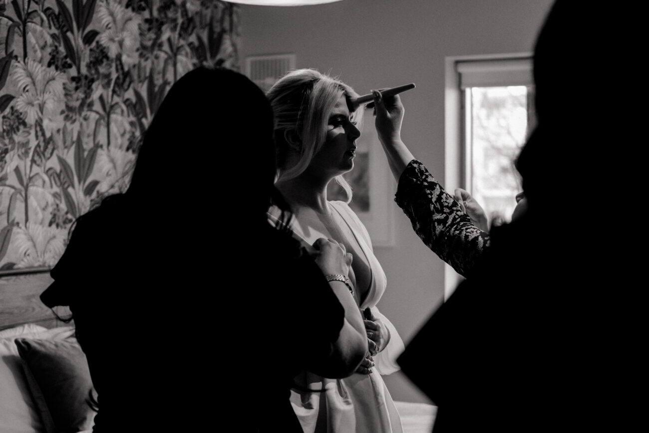 silhouette of bride getting final touches. Candid wedding photography