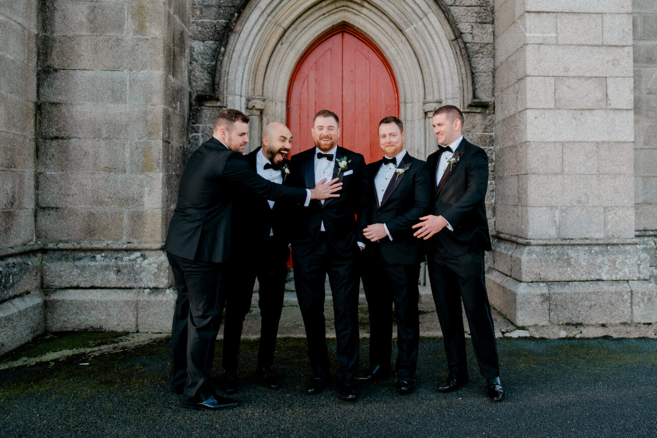 portrait of groom and his groomsmen having fun at the church. wedding at Powerscourt estate