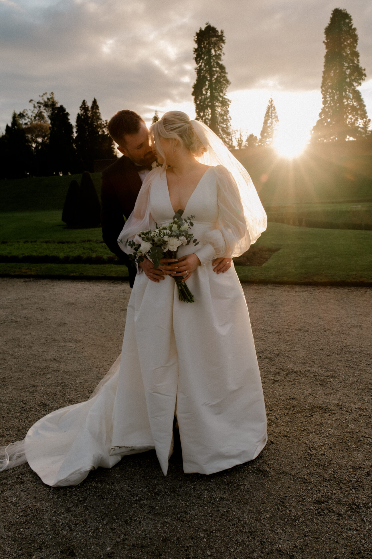 couple embracing in the sunset at Powerscourt Gardens, Powerscourt wedding, candid wedding photography
