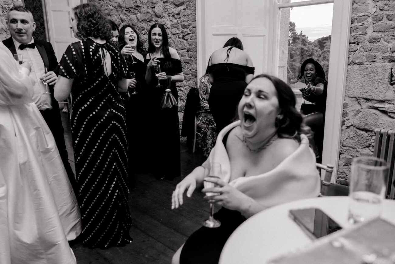 guests laughing at each other during cocktail hour at Powerscourt Gardens, candid wedding photography