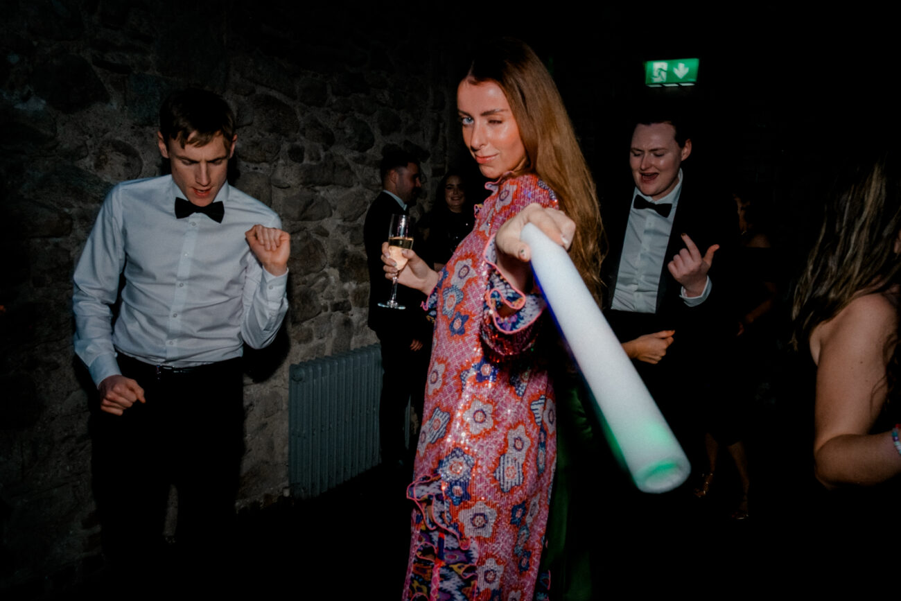Guests dancing and looking at the camera, candid wedding photography