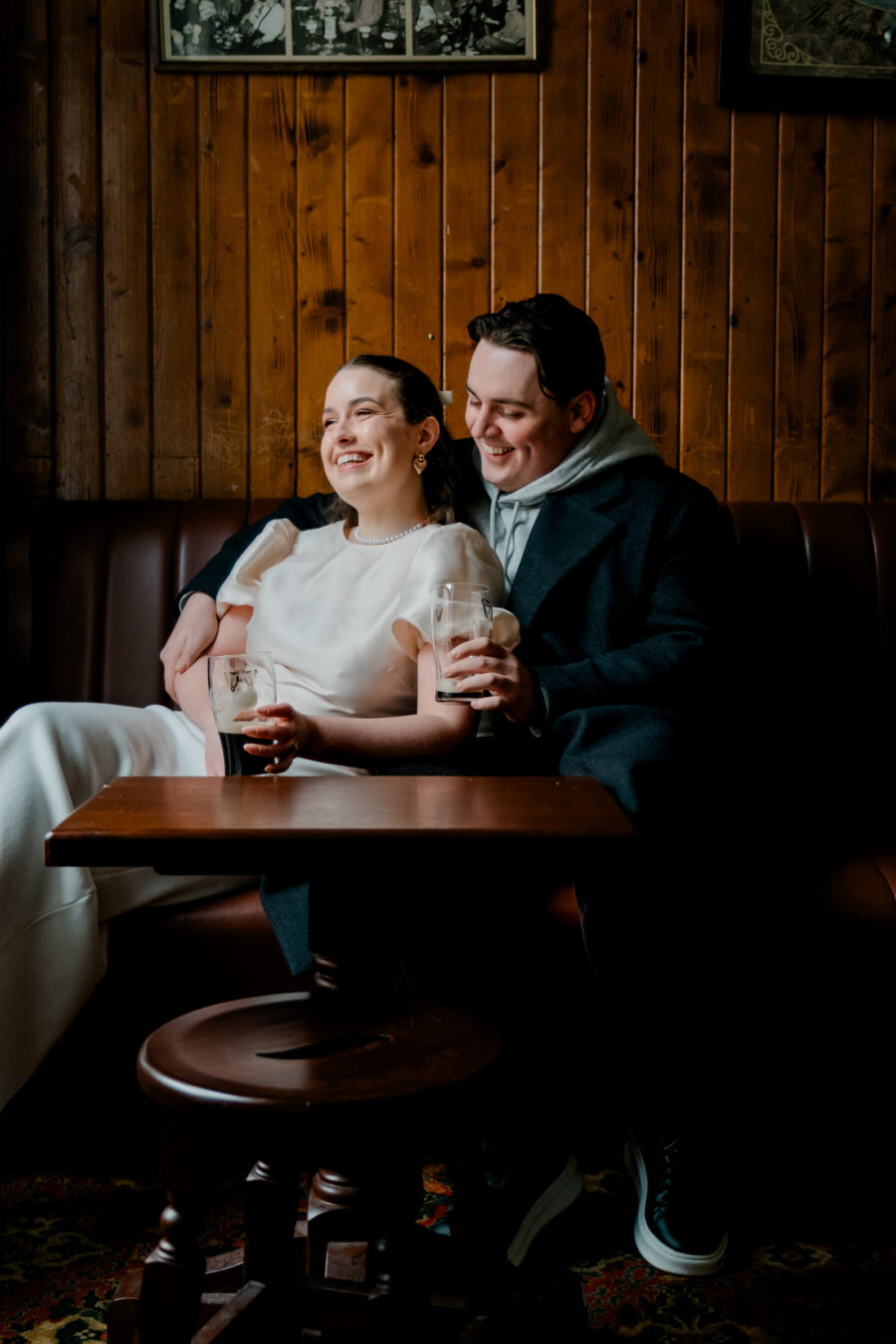 Couple cosied up on a couch drinking Guinness in O'Donoghues Pub in Dublin