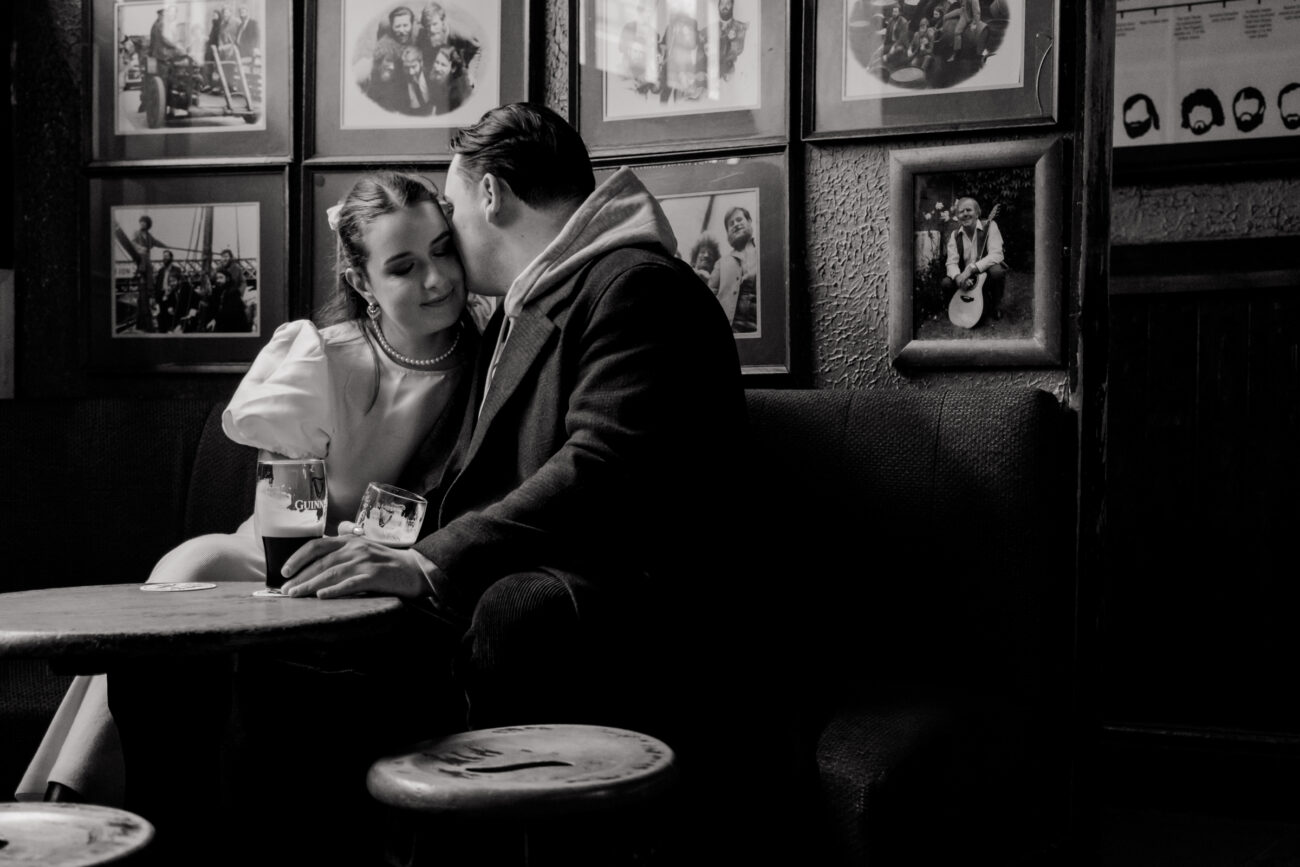 Couple kissing and drinking Guinness in O'Donoghues Pub in Dublin