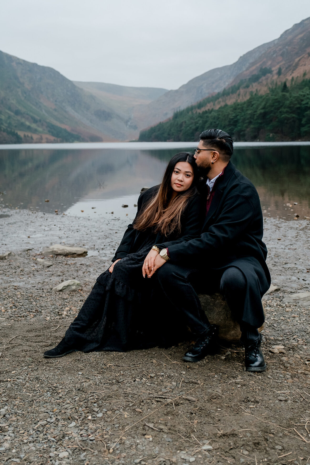 Couple sitting at the Glendalough Upper lake in Wicklow. Secret proposal shoot in Wicklow