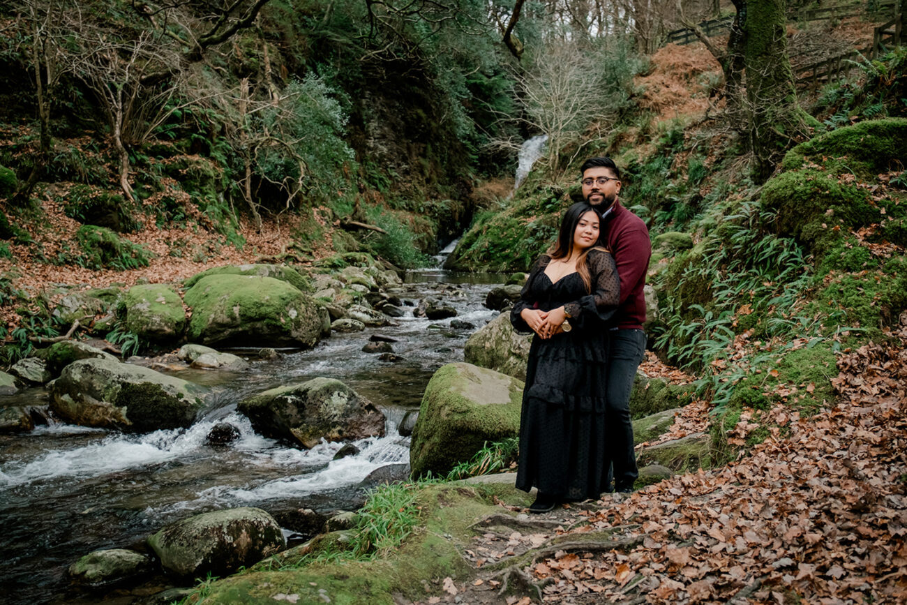 couple embracing next to the waterfall in Glendalough, Wicklow. Secret proposal shoot in Glendalough