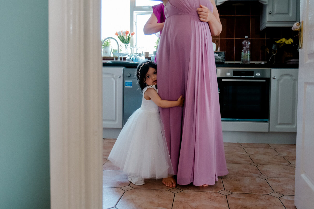 flower girl holding her mums legs
