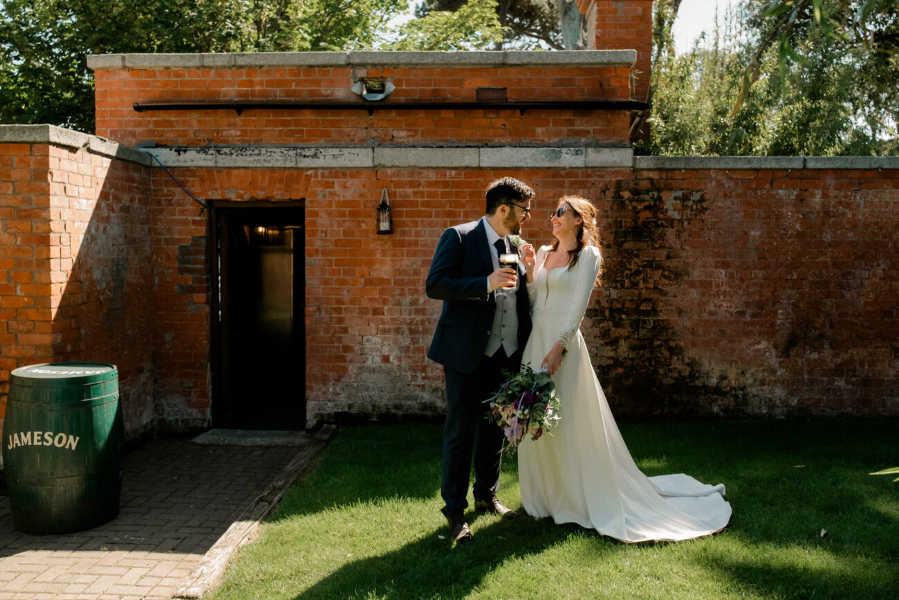 Bride and groom having a pint in the gardens of Portmarnock Resort