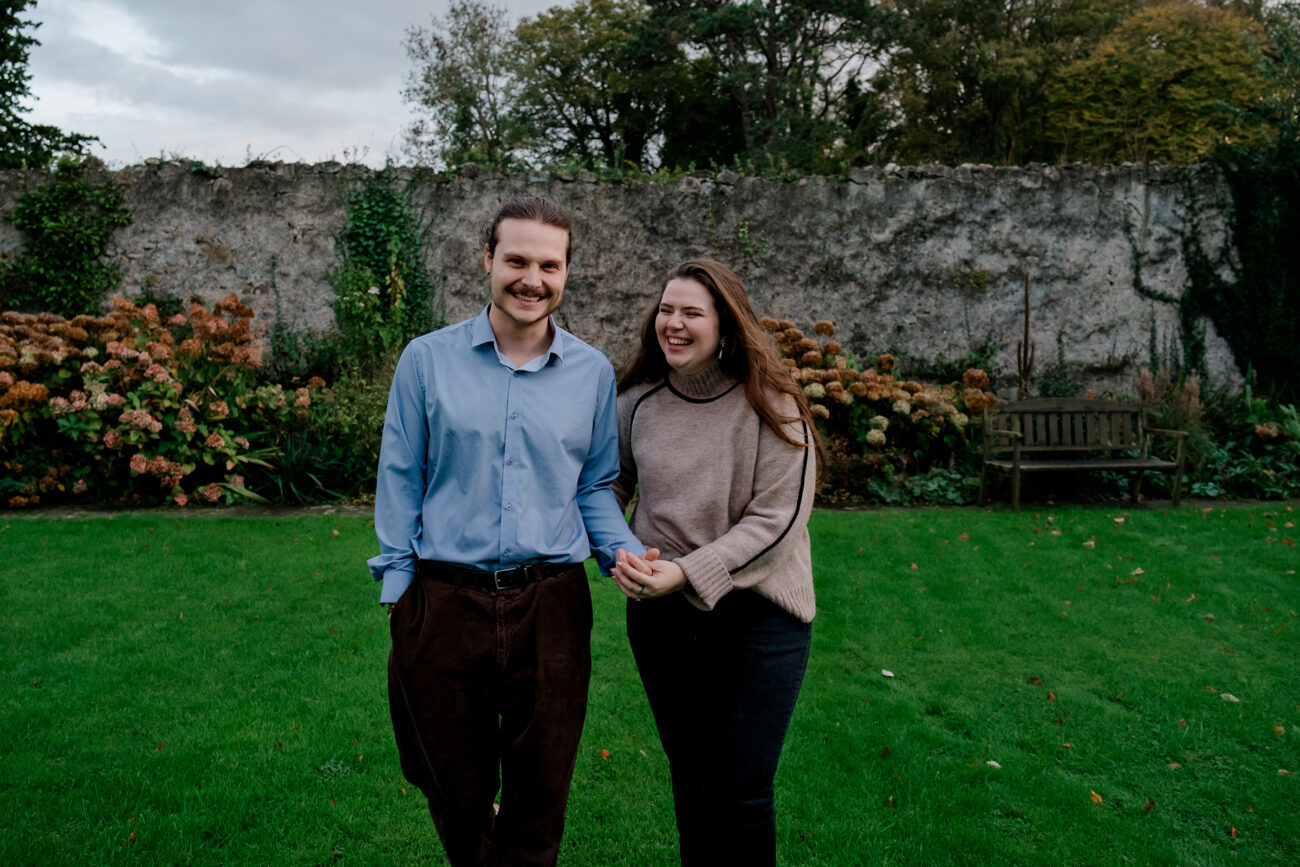 Couple walking and laughing at Howth Castle engagement shoot
