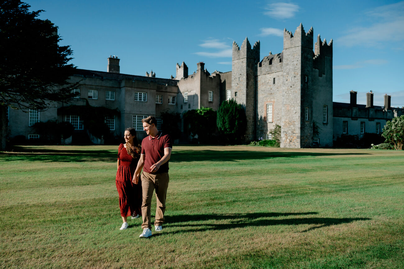 Couple walking in the grounds of Howth Castle and the castle in the background